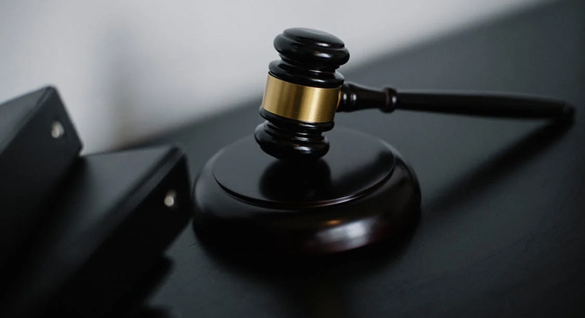 Wooden judge's gavel resting on a desk, symbolizing justice, law, and legal proceedings in a courtroom setting.