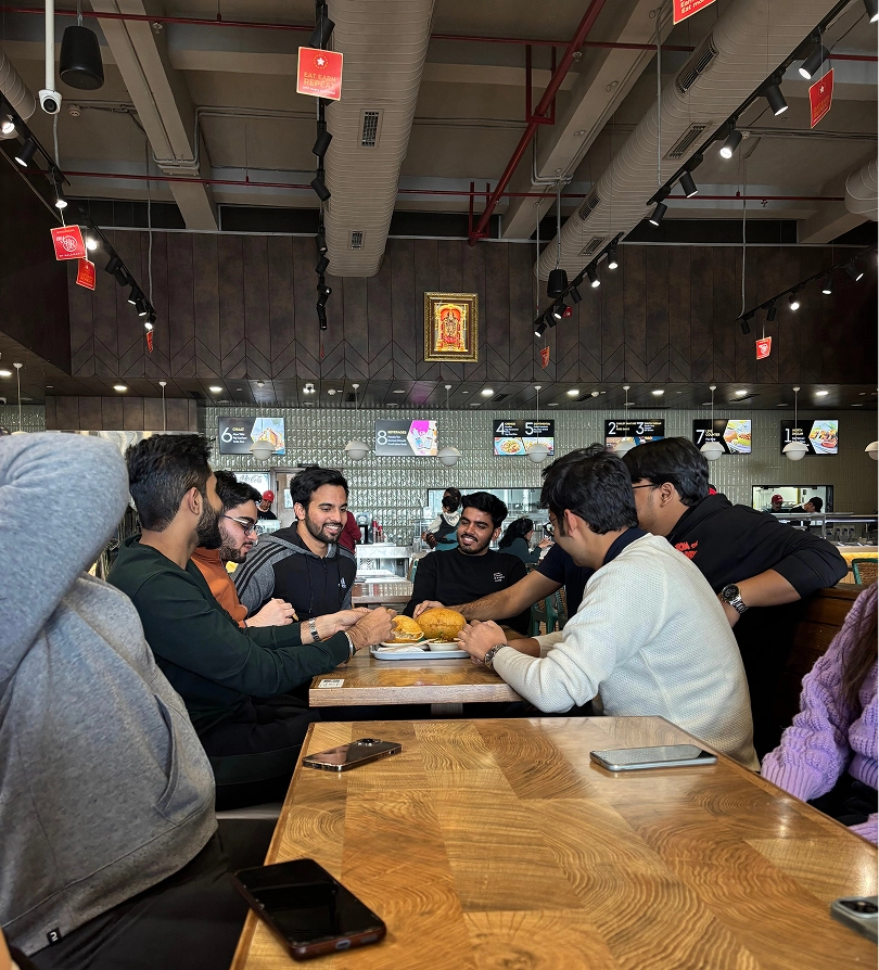 Group of friends enjoying fast food at a restaurant with a lively atmosphere.